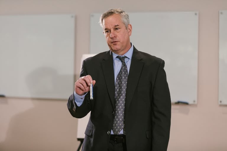 Businessman in suit presenting in office setting, emphasizing leadership and confidence.